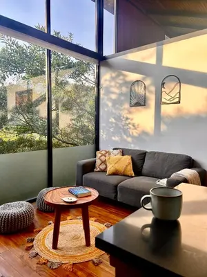 a living room with a couch and a table at NATURAVE HOME - Tiny house with mountain view in Monteverde Costa Rica