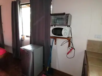 a microwave sitting on top of a refrigerator at Cabinas casa las flores in Montezuma