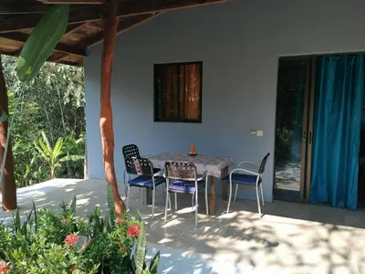 a table and chairs sitting on a patio at Cabinas casa las flores in Montezuma