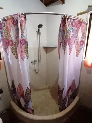 a shower with a shower curtain in a bathroom at Cabinas casa las flores in Montezuma