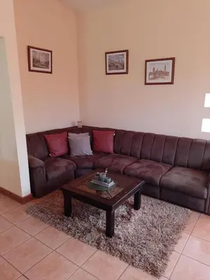 a living room with a brown couch and a coffee table at Casa Victoria in Orosí