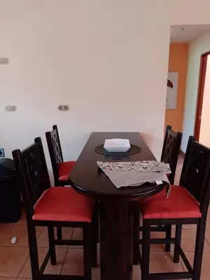 a wooden table with red chairs and a table with a napkin on it at Casa Victoria in Orosí