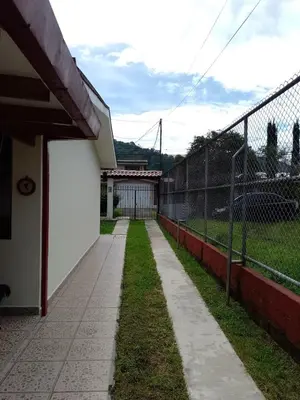 a fence and a walkway next to a building at Casa Victoria in Orosí