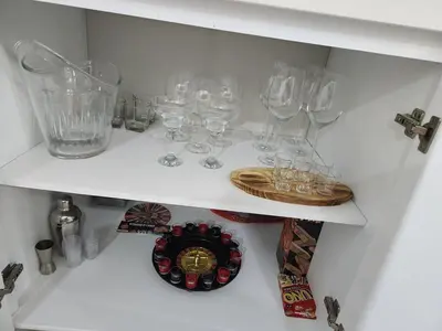 a shelf with wine glasses and a plate on it at Beautiful and cozy home in Alajuela City