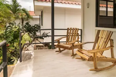 two wooden chairs sitting on the porch of a house at Drift Away Lodge CR in Santa Cruz