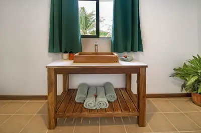 a wooden table with a sink and towels under it at Drift Away Lodge CR in Santa Cruz
