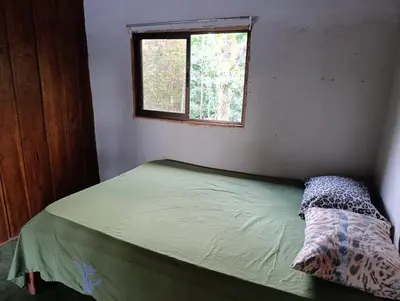 a small bed in a room with a window at Cabaña el mirador in San José