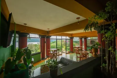 a living room with a couch and some plants at Lake Arenal Hotel, Brewery & Farm in Tilarán