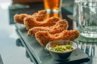 a tray of fried onion rings with a bowl of dipping sauce at Lake Arenal Hotel, Brewery & Farm in Tilarán