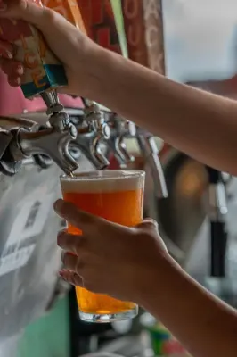 a person is holding a glass of beer at Lake Arenal Hotel, Brewery & Farm in Tilarán