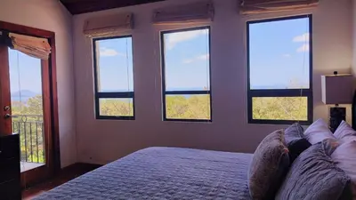 a bedroom with four windows and a bed in it at Villa Estrellas - Stunning Ocean-Views, Potrero, spacious 4 BR Villa in Potrero