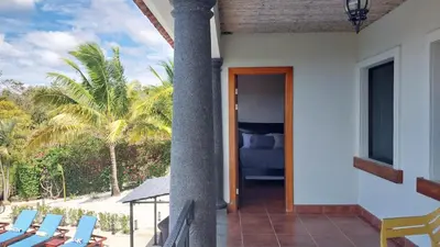 a porch of a house with a bed and chairs at Villa Estrellas - Stunning Ocean-Views, Potrero, spacious 4 BR Villa in Potrero