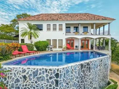 a house with a swimming pool in front of a house at Villa Estrellas - Stunning Ocean-Views, Potrero, spacious 4 BR Villa in Potrero