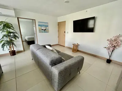 a living room with a couch and a flat screen tv at 0905 Viva Jaco in Jacó