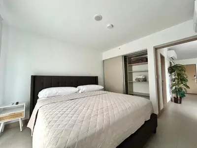 a bedroom with a large bed with white sheets at 0905 Viva Jaco in Jacó