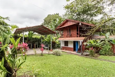 a house with a garden in front of it at Gamboa Cabin - Delightful Couples Vacation Cabin in Fortuna