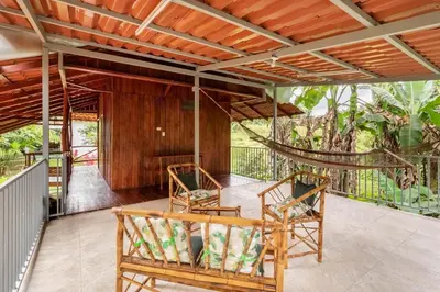 a porch with two chairs and a hammock at Gamboa Cabin - Delightful Couples Vacation Cabin in Fortuna
