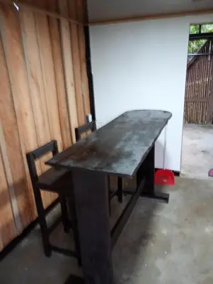 a wooden table with two chairs sitting around it at Marcana Occidente in San Ramón