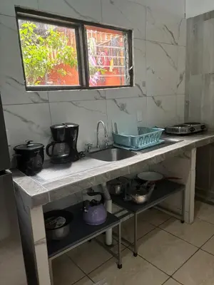 a kitchen counter with a sink and some pots and pans at Depa Koral in Puerto Limón