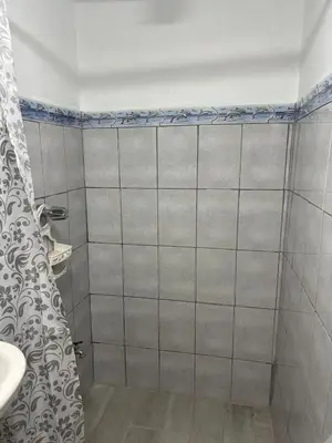 a bathroom with a shower curtain and a sink at Depa Koral in Puerto Limón