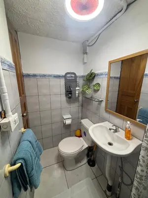 a bathroom with a toilet and a sink and a mirror at Depa Koral in Puerto Limón