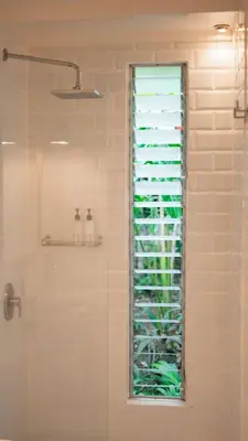 a shower with a window in a bathroom at Surf Casitas - Low Tide Bungalow in Santa Teresa Beach