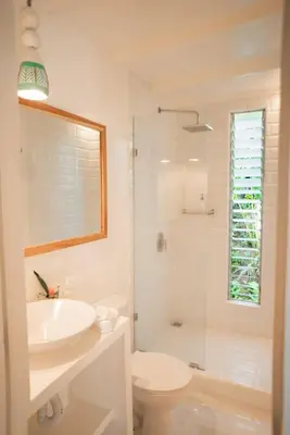 a bathroom with a sink and a toilet and a shower at Surf Casitas - Low Tide Bungalow in Santa Teresa Beach