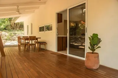 a dining room with a table and a potted plant at Arroyo Tranquilo - Steps to the Beach in Santa Teresa Beach