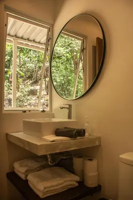 a bathroom with a sink and a mirror at Arroyo Tranquilo - Steps to the Beach in Santa Teresa Beach