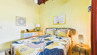 a bedroom with a bed and a table with a lamp at Casa Colibrí - Villagio 372A in Potrero