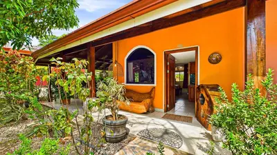 an orange house with an open door and some plants at Casa Colibrí - Villagio 372A in Potrero
