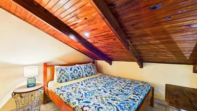 a small bedroom with a bed with a wooden ceiling at Casa Colibrí - Villagio 372A in Potrero