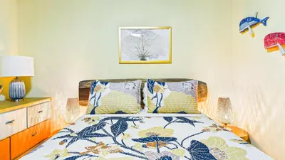 a bedroom with a bed with a floral bedspread at Casa Colibrí - Villagio 372A in Potrero