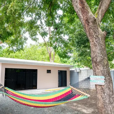 a hammock tied to a tree in front of a house at Casa Cerca de Tamarindo,ConchalFlamingo,Potrero,Playa Grande,Avellanas,Langosta in Huacas
