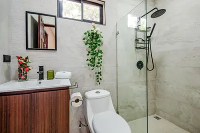 a bathroom with a toilet and a glass shower at Casa Cerca de Tamarindo,ConchalFlamingo,Potrero,Playa Grande,Avellanas,Langosta in Huacas