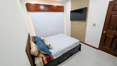 a small bedroom with a bed and a tv at Los Mangos Nosara in Nosara