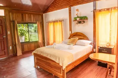 a bedroom with a large bed in a room at ROQUI Cozy Beachfront Cabin in Uvita