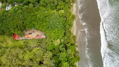 an aerial view of a house and the ocean at ROQUI Cozy Beachfront Cabin in Uvita