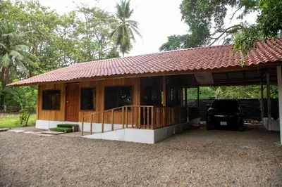 a house with a car parked in front of it at ROQUI Cozy Beachfront Cabin in Uvita