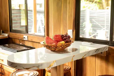a bowl of fruit on a counter in a kitchen at ROQUI Cozy Beachfront Cabin in Uvita