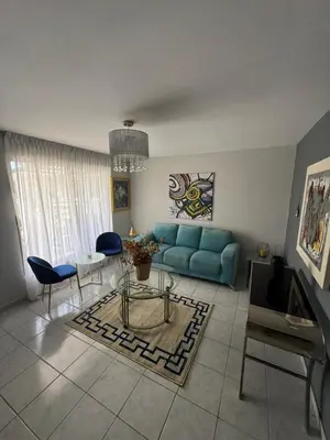 a living room with a blue couch and a table at Casa Arte Jaco in Jacó