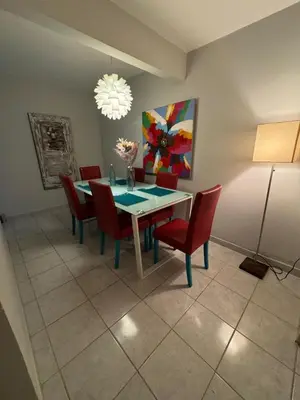 a dining room with a table and red chairs at Casa Arte Jaco in Jacó