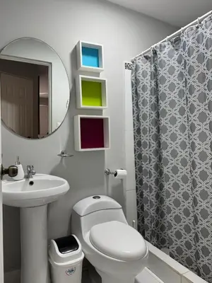 a bathroom with a toilet and a sink and a mirror at Casa Arte Jaco in Jacó