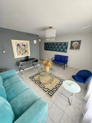 a living room with a blue couch and a table at Casa Arte Jaco in Jacó