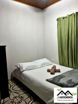 a bedroom with a bed and a green shower curtain at Apartamento Lulú in Uvita
