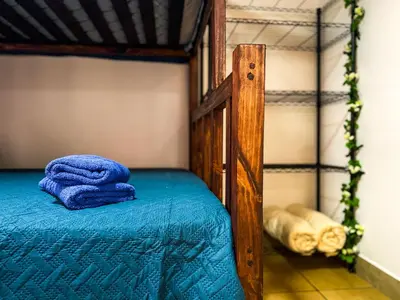a bunk bed with a blue blanket on it at Brisa Amatista - Casa completa y centrica en San Ramón #2 in San Ramón