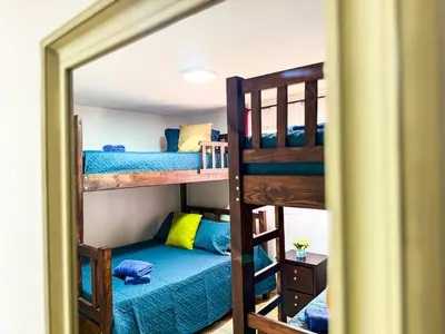 a bunk bed room with two bunk beds and a mirror at Brisa Amatista - Casa completa y centrica en San Ramón #2 in San Ramón