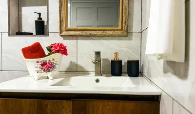 a bathroom sink with a vase of flowers on it at Brisa Amatista - Casa completa y centrica en San Ramón #2 in San Ramón