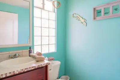 a bathroom with a toilet and a sink and a window at Altavista #3 in Jacó