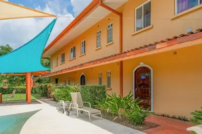 an orange house with chairs and a swimming pool at Altavista #3 in Jacó